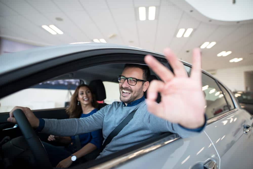 conductor feliz haciendo senal ok en auto